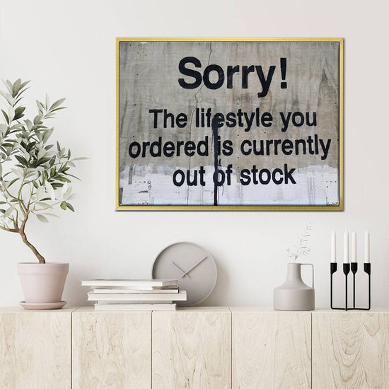 gold frame banksys statement canvas print hanging on the wall